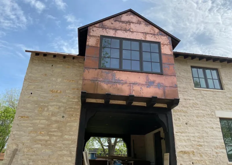 Copper metal panel facade on a stone building for Roof Repair in Jonesboro